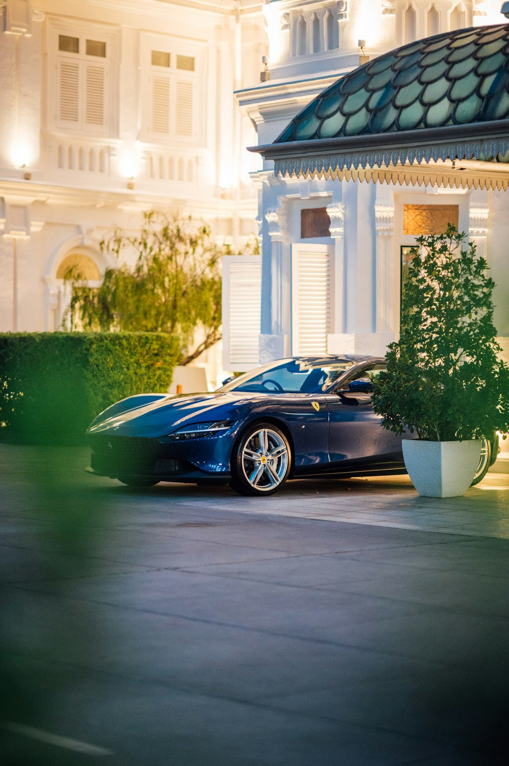 a blue sports car parked in front of a white building