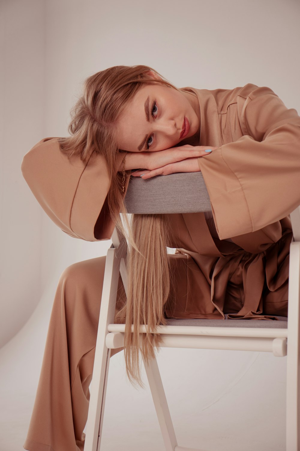 a woman sitting on a chair with her head on her hand