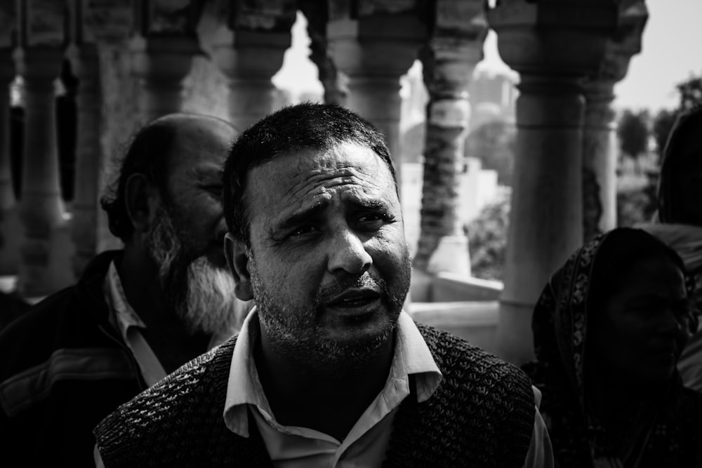 a black and white photo of a man in a crowd