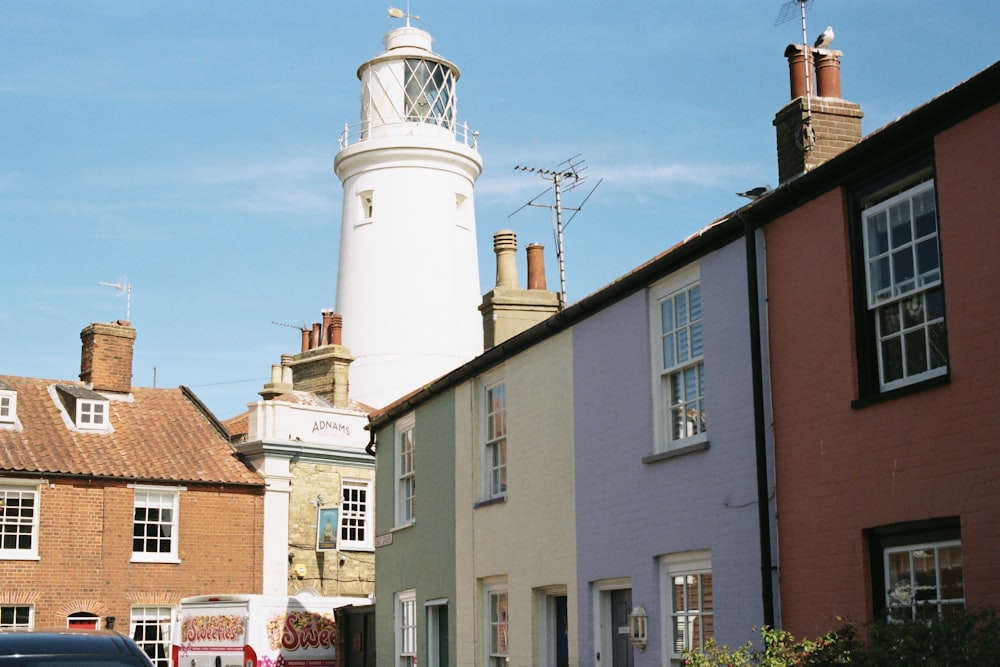 a car parked on the side of a road next to a light house