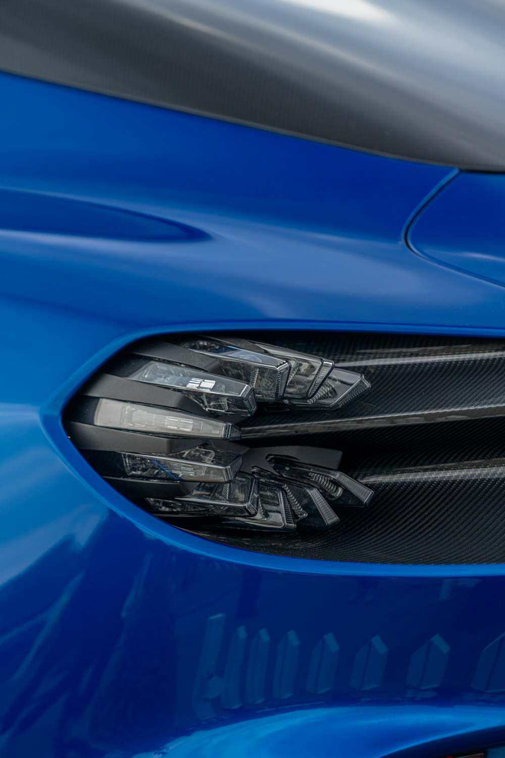 a close up of the front of a blue sports car