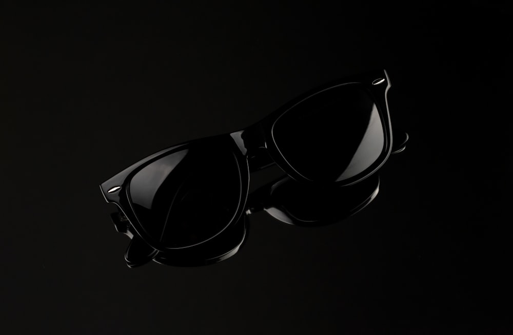 a pair of black sunglasses on a black background