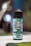 A bottle of e-liquid is prominently displayed, featuring a label with the text 'Ultimate E-Liquid Menthol Original.' The label is decorated with images of mint leaves and an icy background, suggesting a cooling menthol flavor. The bottle cap is black, and the background is blurry, with bokeh lights, creating a focused and isolated view of the product.