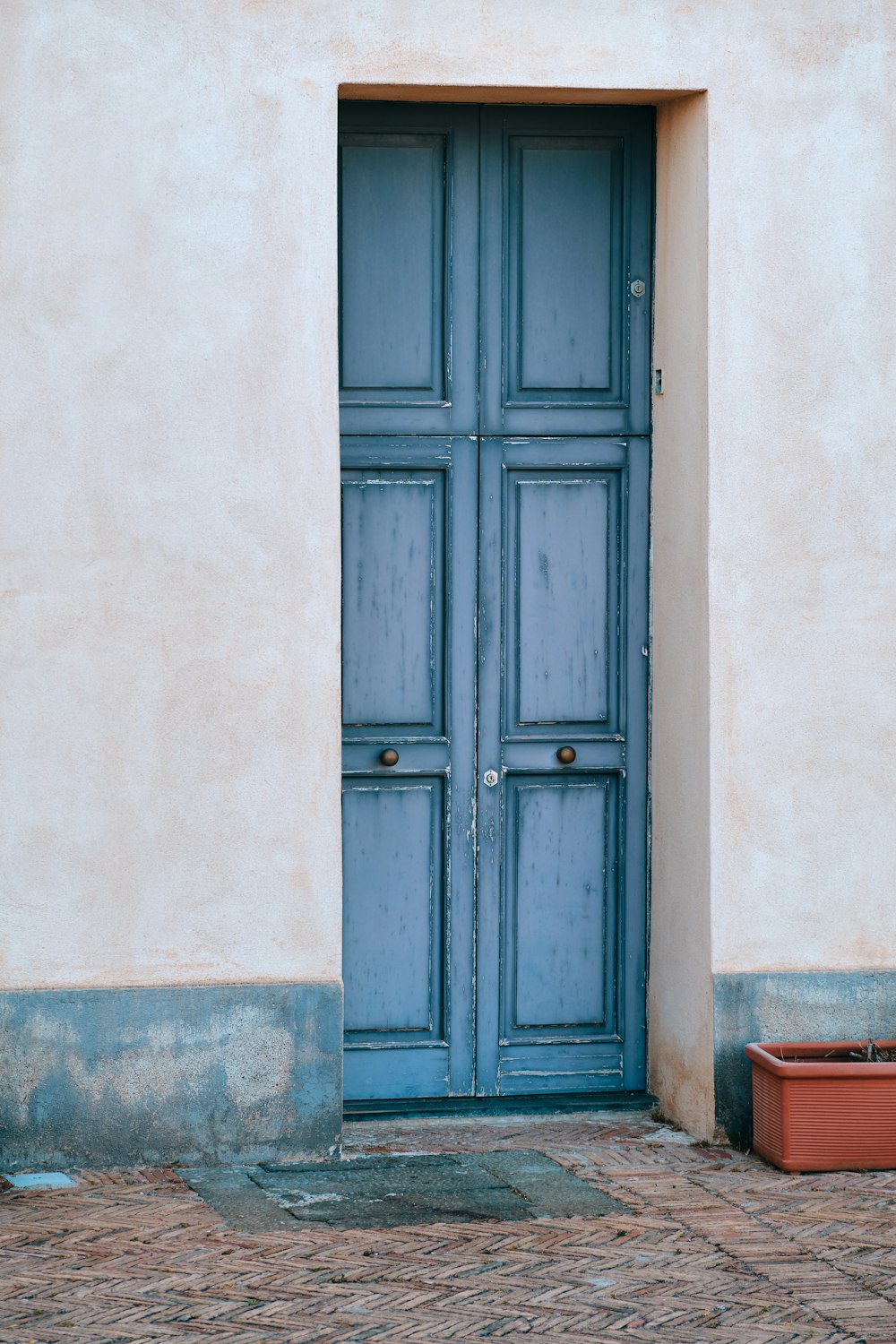 a blue door with a planter in front of it