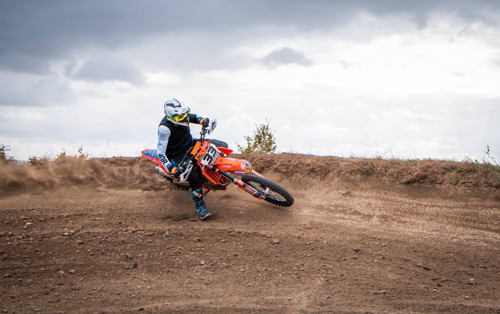 a man riding a dirt bike on top of a dirt field