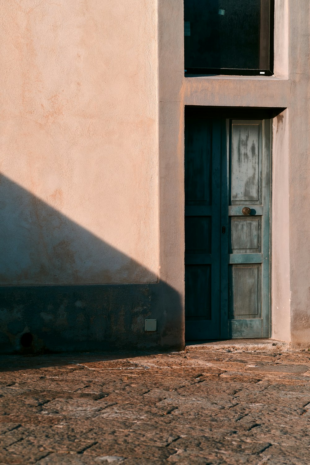 a cat sitting on the ground in front of a door