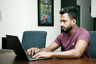 a man sitting in front of a laptop computer