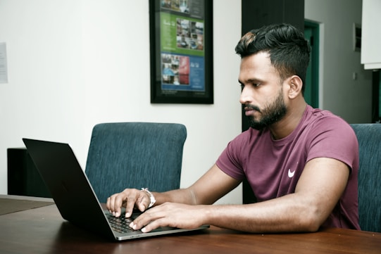 a man sitting in front of a laptop computer