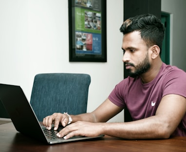 a man sitting in front of a laptop computer