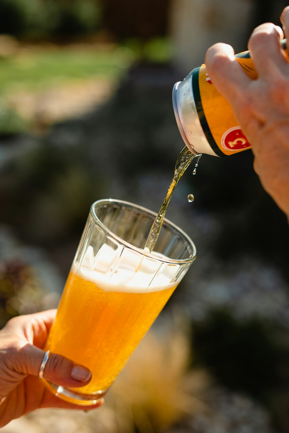 a person pouring a drink into a glass