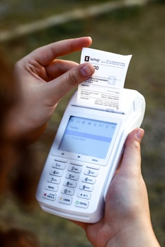a person holding a cell phone and a receipt
