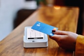 a person holding a credit card in front of a machine