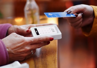 two people exchanging a credit card at a table