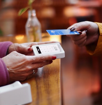 two people exchanging a credit card at a table