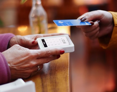 two people exchanging a credit card at a table