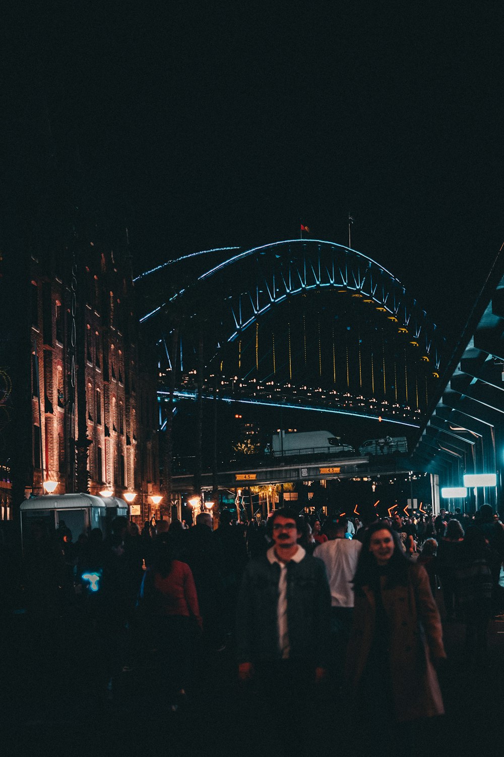 a group of people walking down a street at night