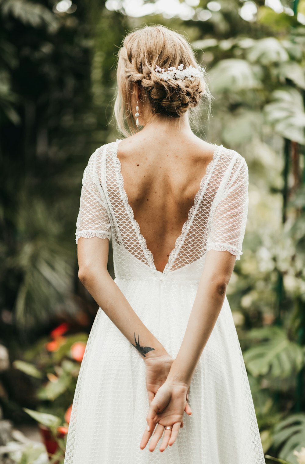 a woman in a white dress standing in a forest