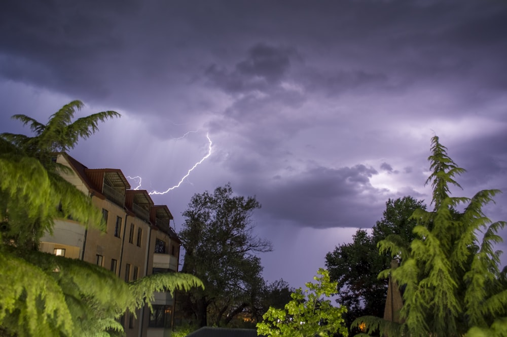 a lightning bolt is seen in the sky over a residential area