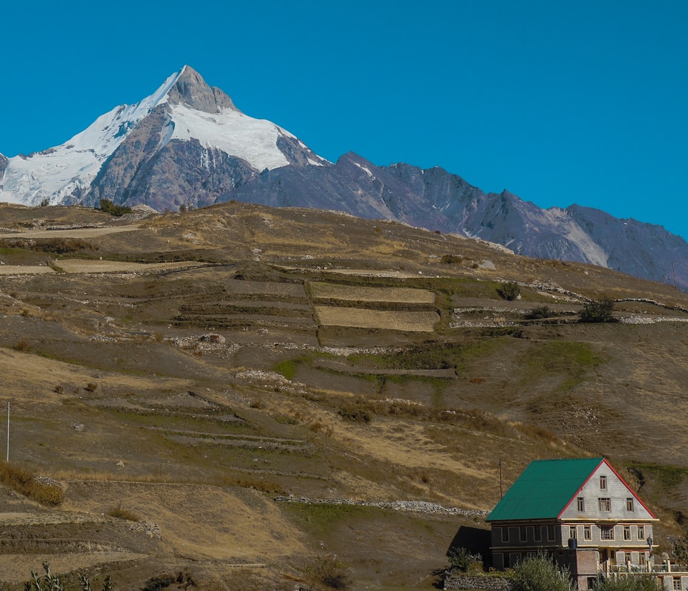 a house on a hill with a mountain in the background