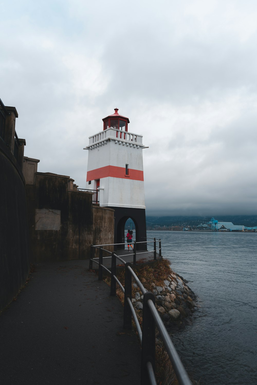 a red and white lighthouse sitting on top of a pier