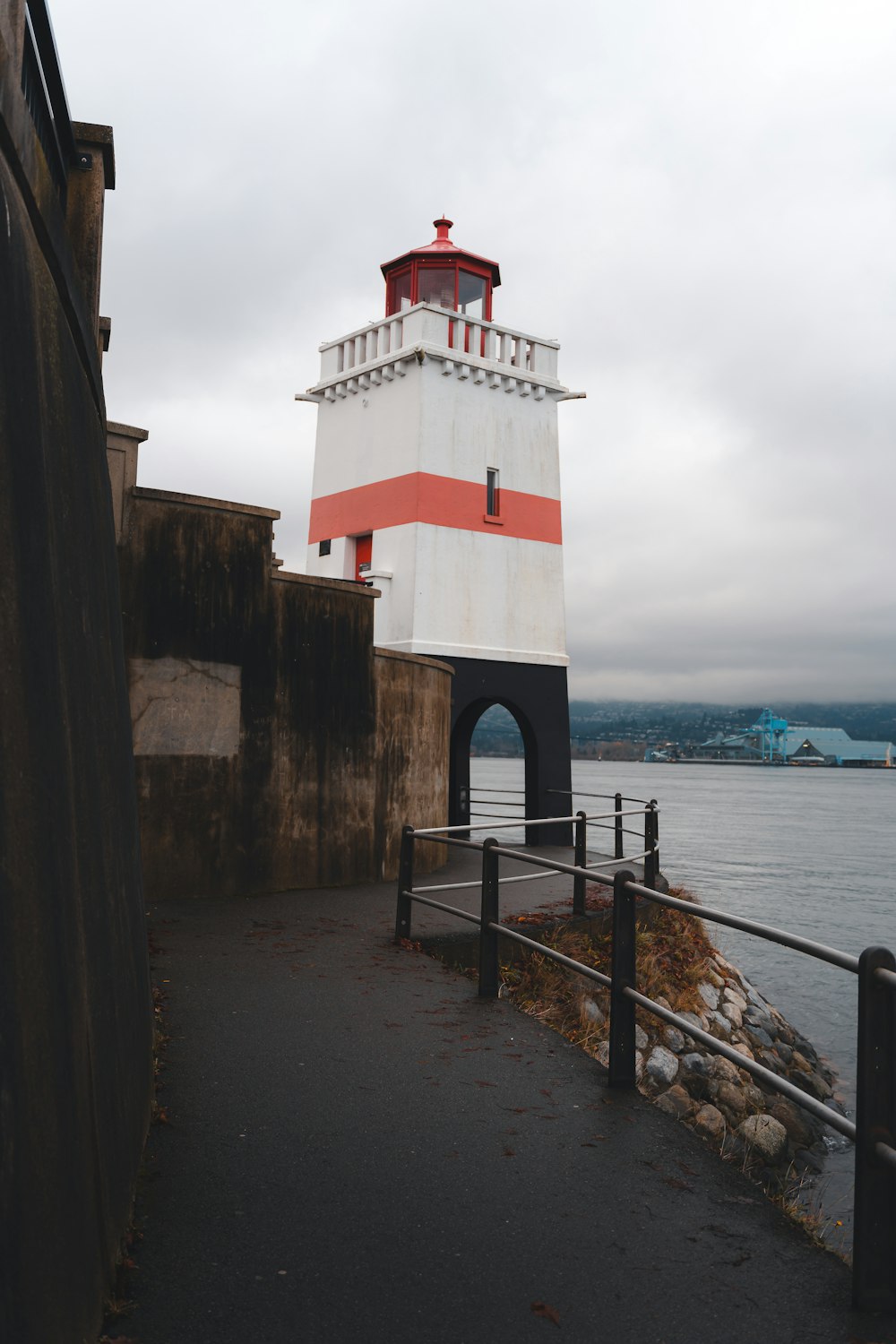 a red and white light house next to a body of water