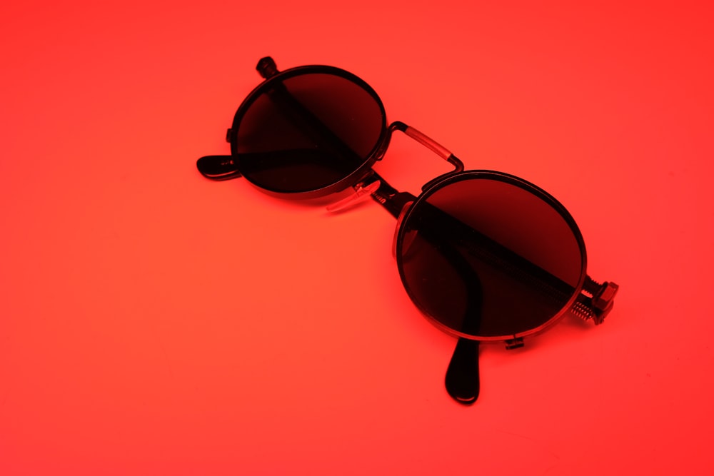 a pair of black sunglasses on a red background