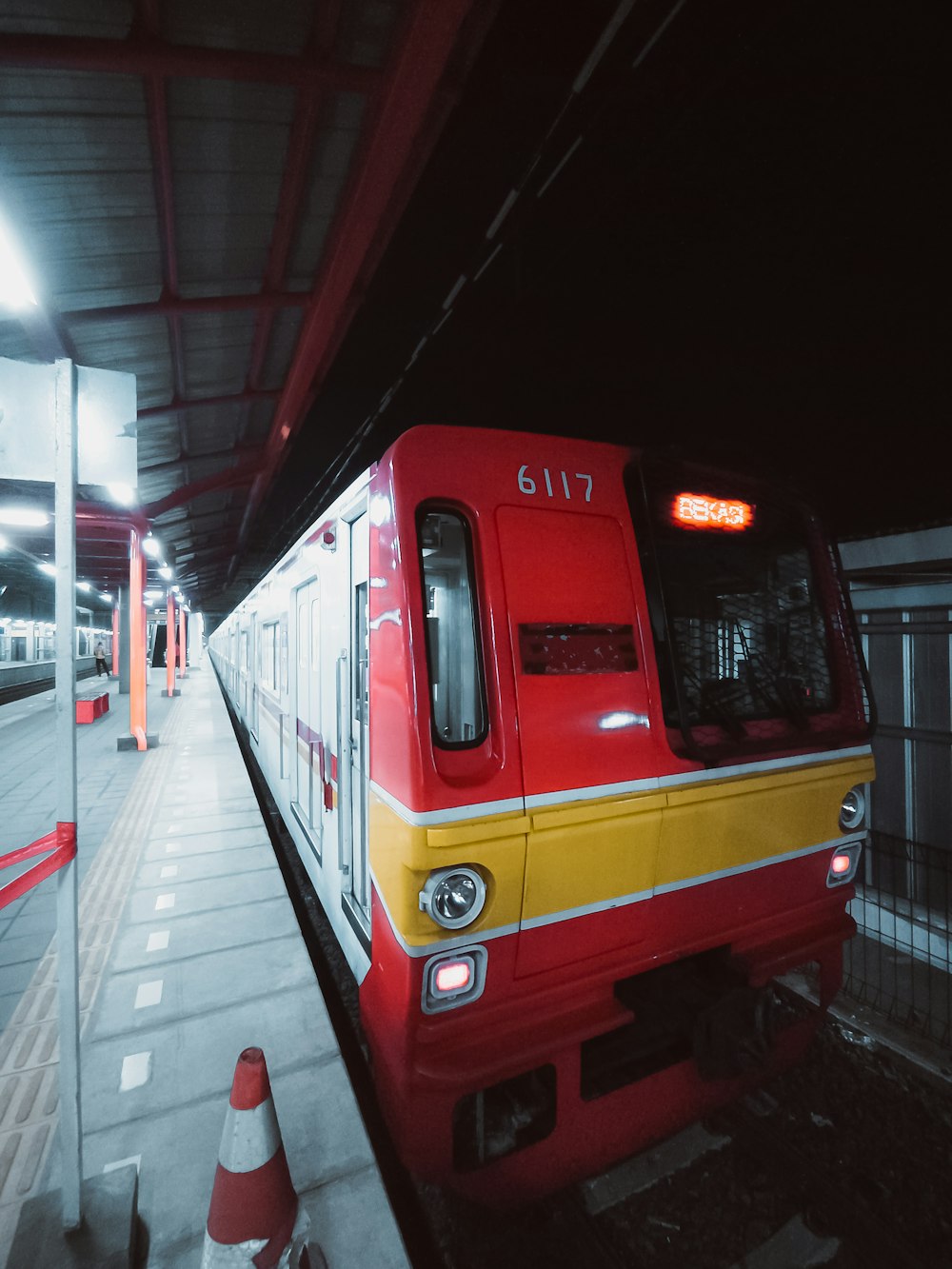 a red and yellow train pulling into a train station