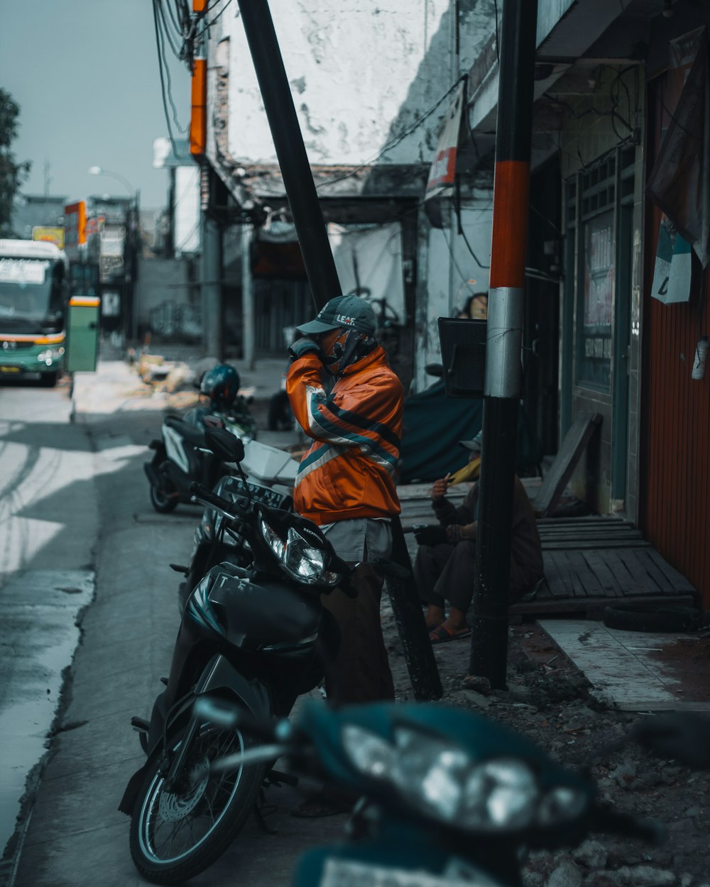 a man standing next to a motorcycle on a city street