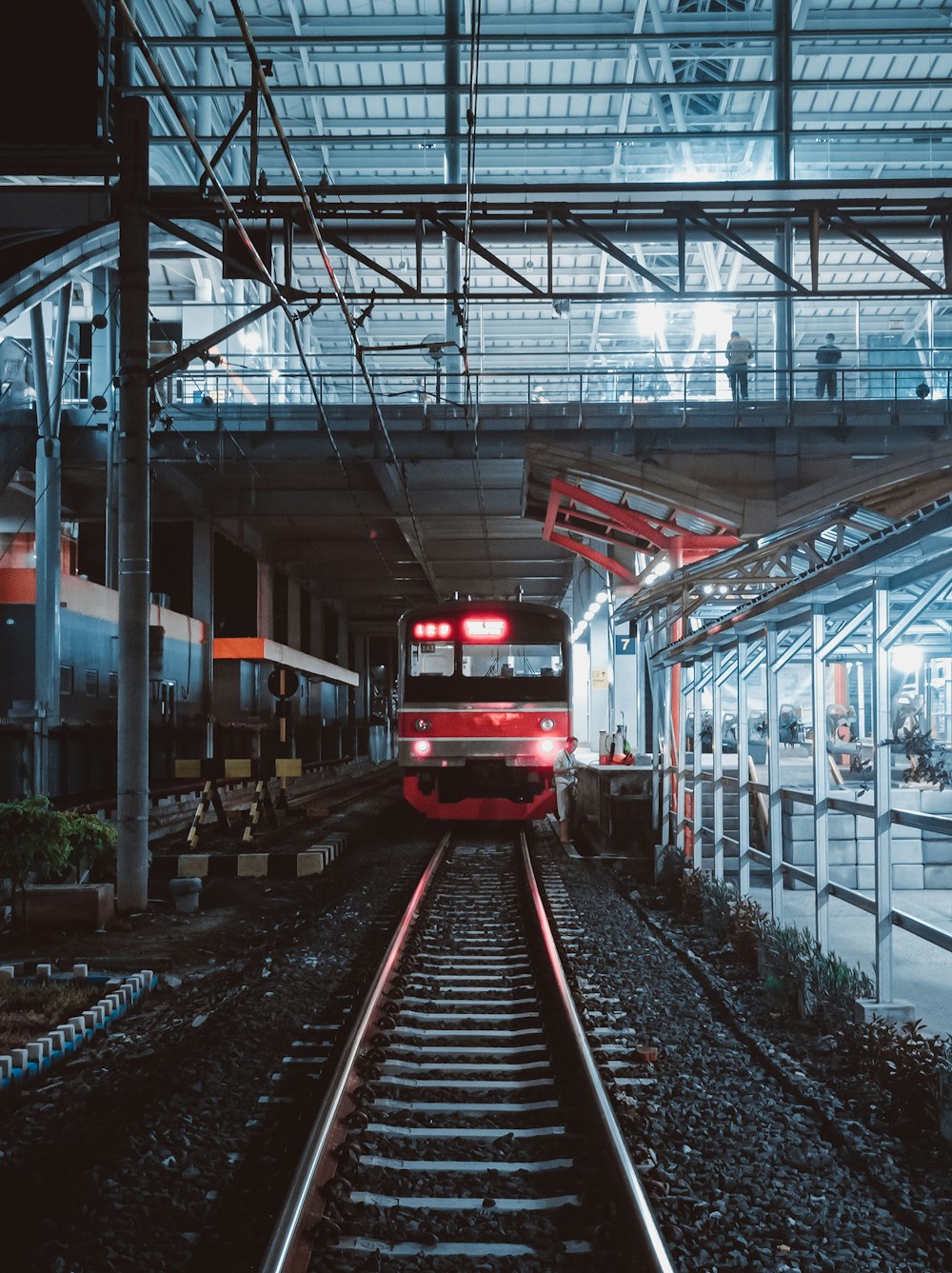 a train traveling down train tracks under a bridge