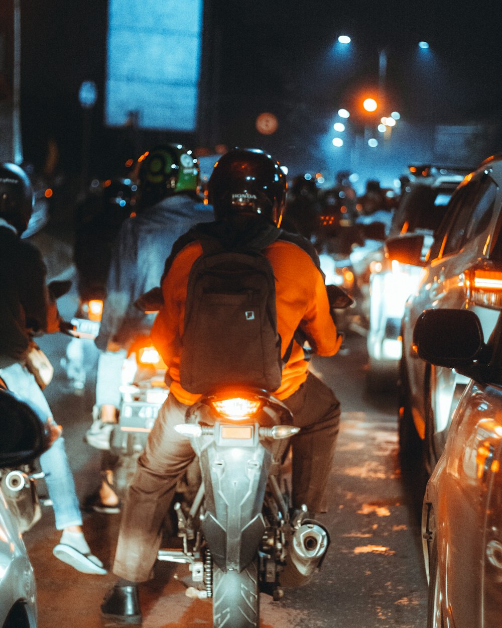 Un uomo che cavalca sul retro di una moto lungo una strada