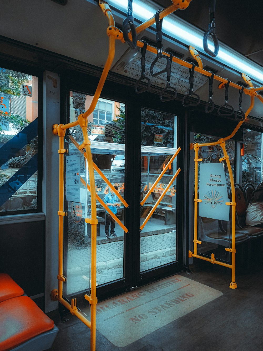 the inside of a bus with yellow railings