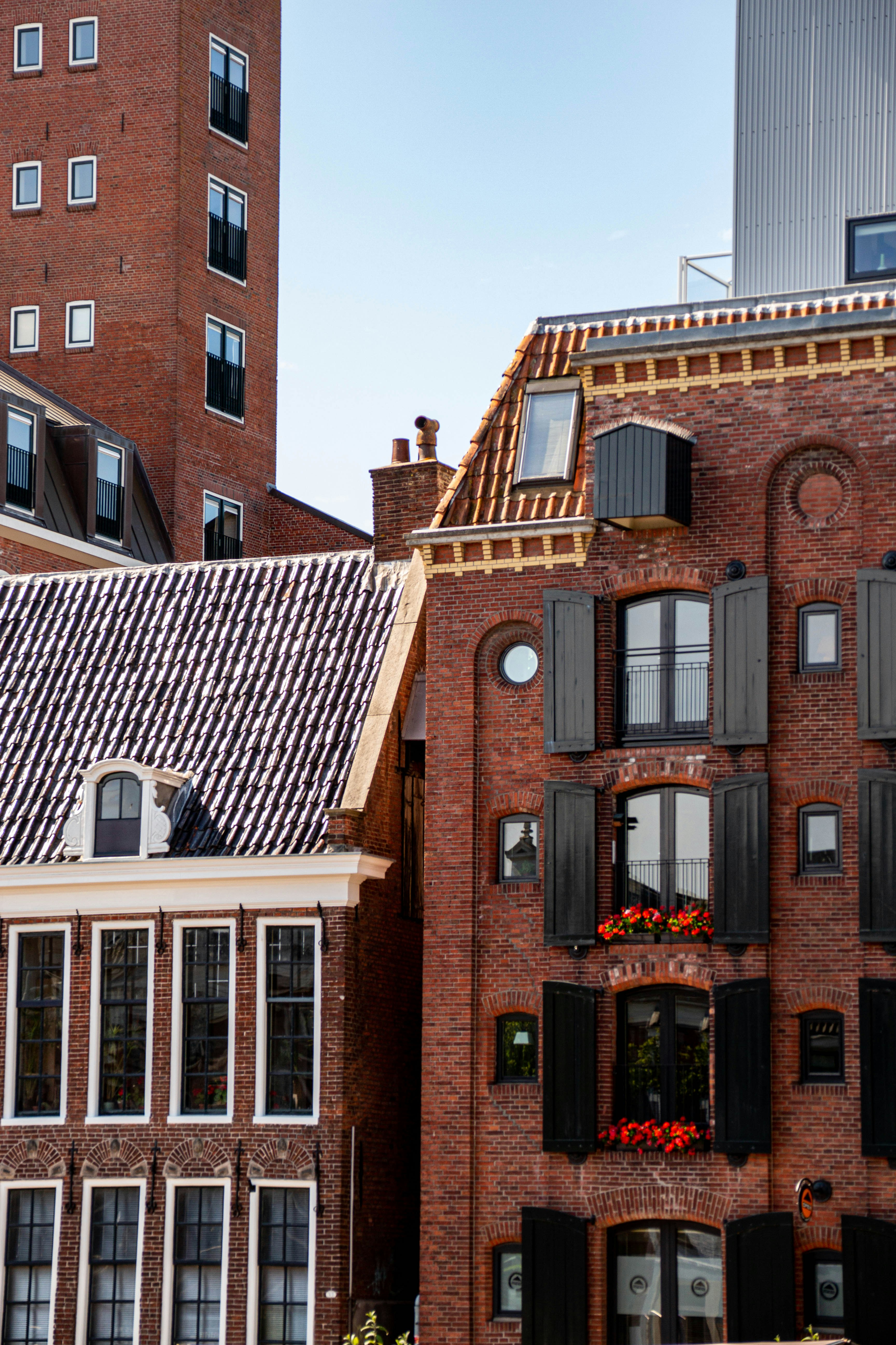 A red brick building with black shutters and windows photo – Free Roof ...