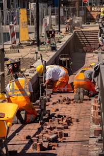 a group of construction workers working on a brick walkway