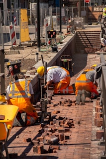 a group of construction workers working on a brick walkway