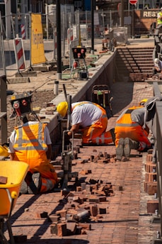 a group of construction workers working on a brick walkway