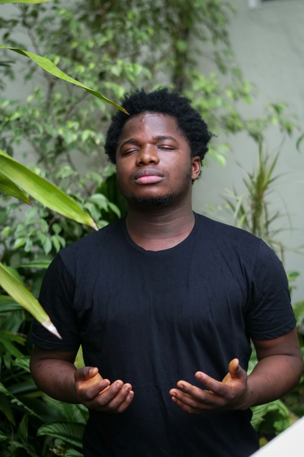 a man standing in front of some plants