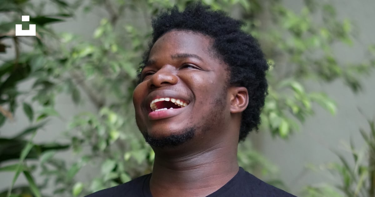 Um homem rindo enquanto está em pé na frente das plantas foto – Imagem ...