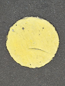 Bright yellow road-marking paint being applied on a busy Nigerian highway.
