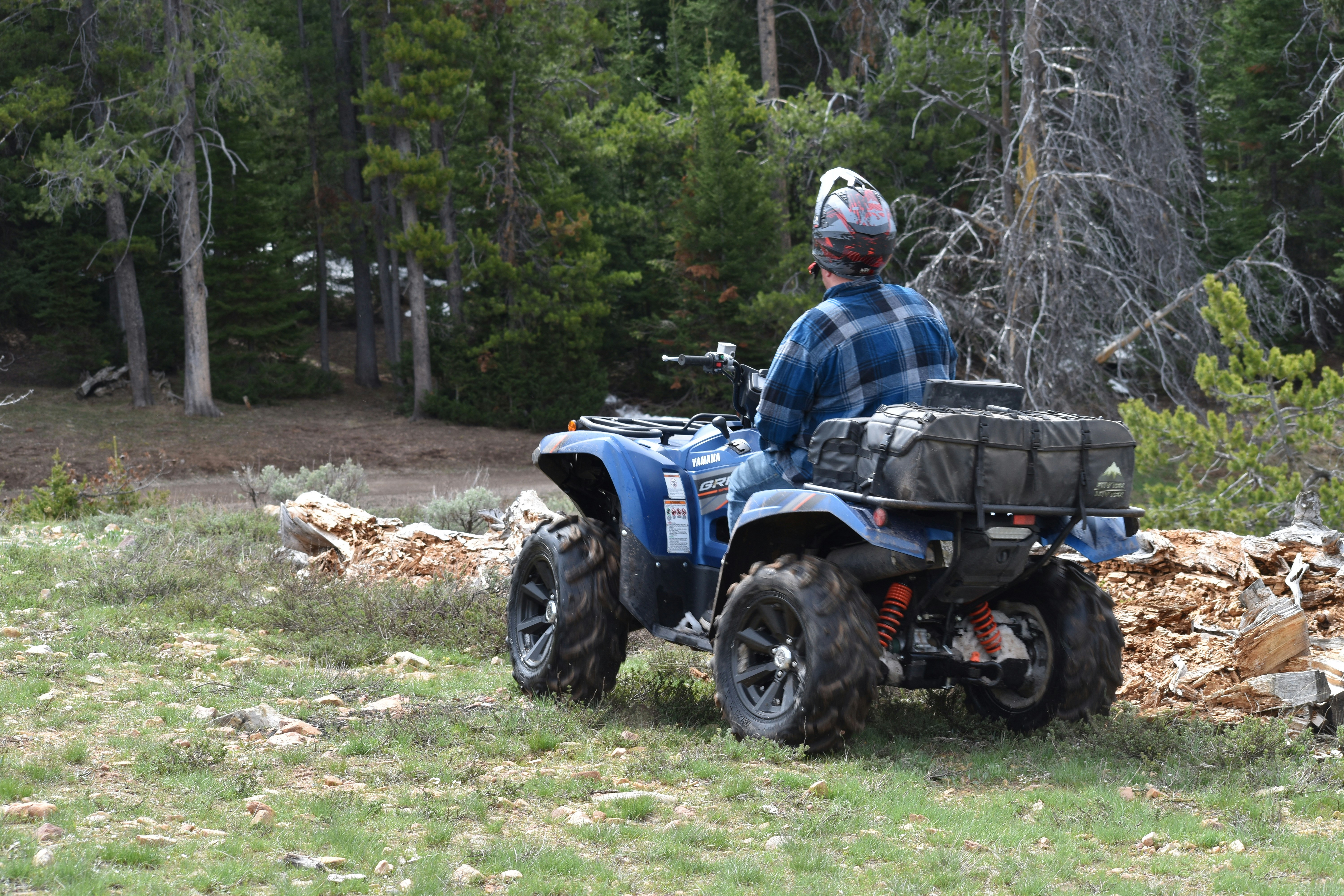 a man riding on the back of a blue ATV
