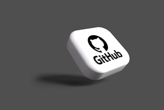 A white, rounded square object with the GitHub logo and name floating on a dark grey background. The logo consists of a white cat silhouette inside a black circle.