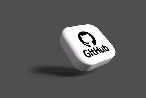 A white, rounded square object with the GitHub logo and name floating on a dark grey background. The logo consists of a white cat silhouette inside a black circle.