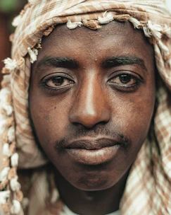 A solemn portrait of an Iranian citizen impacted by the war, eyes reflecting resilience.