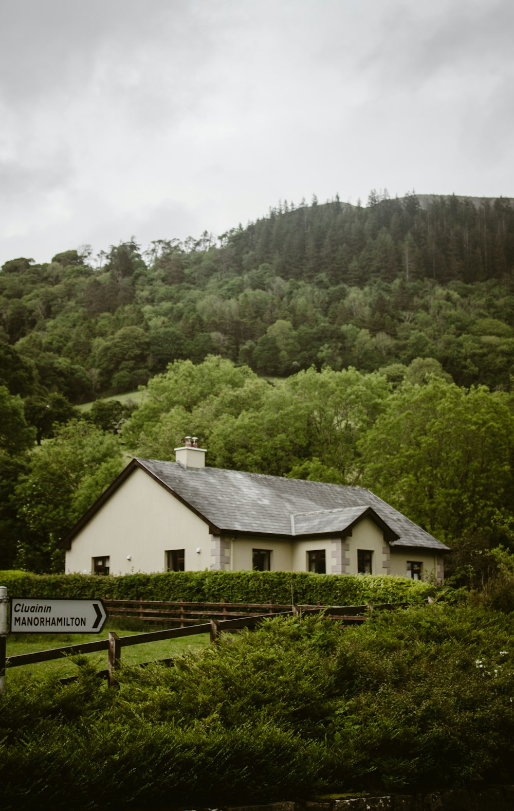 a white house sitting on top of a lush green hillside