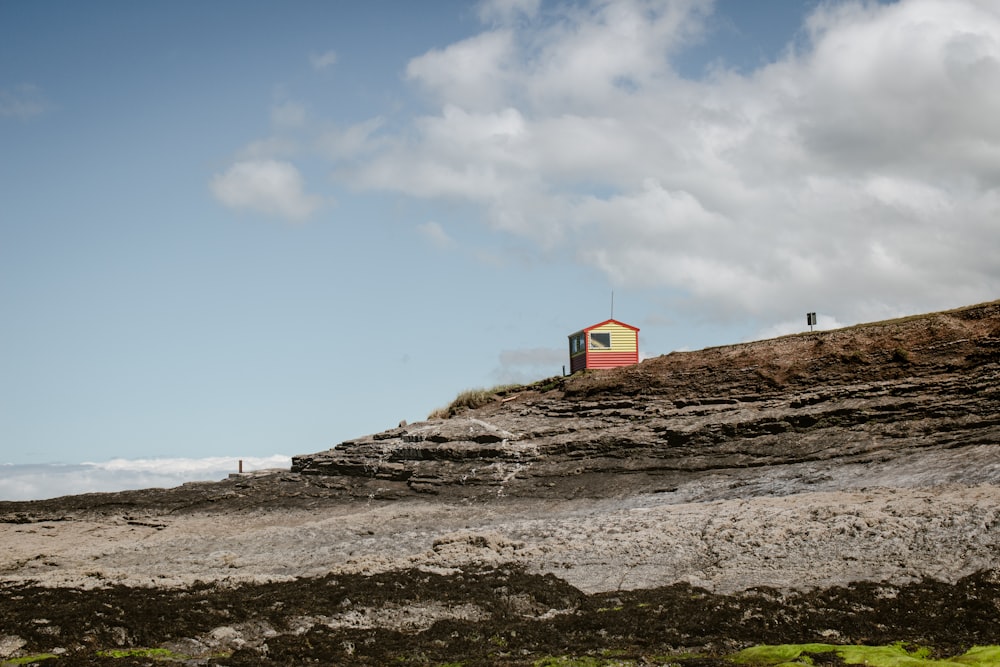 a red and yellow house on top of a hill