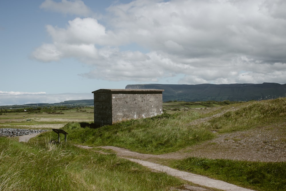 a stone building sitting on top of a lush green hillside