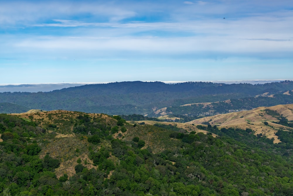 a scenic view of a mountain range with a blue sky in the background