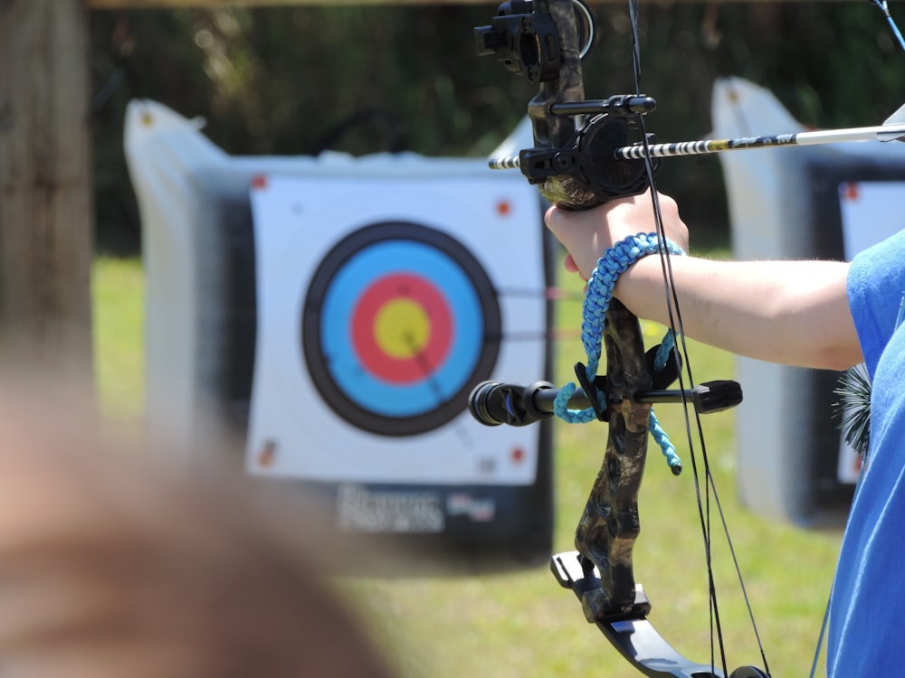 a person holding a bow and aiming an arrow at a target