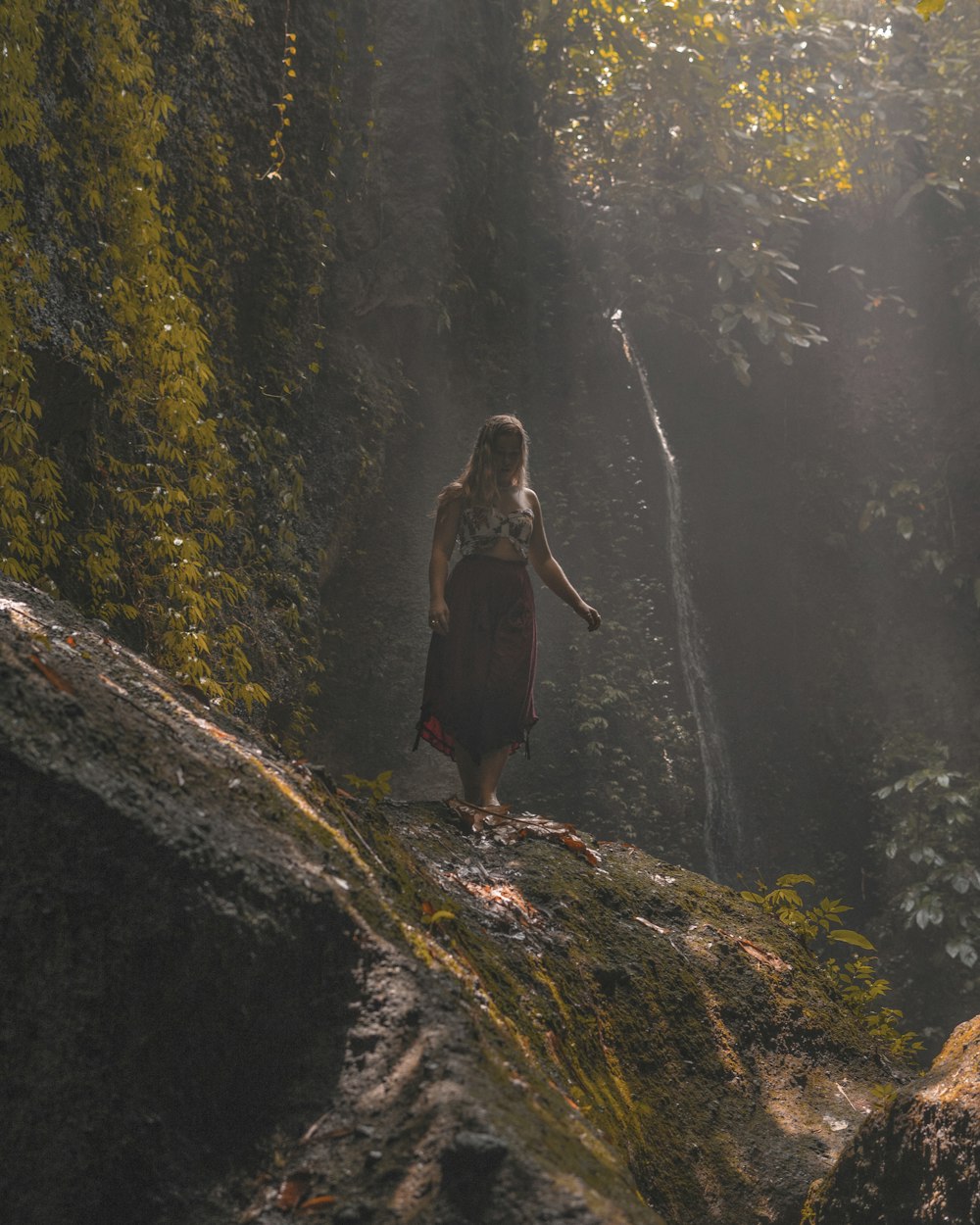 a woman standing on top of a lush green forest