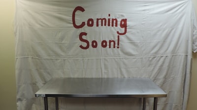 a stainless steel table sitting in front of a banner