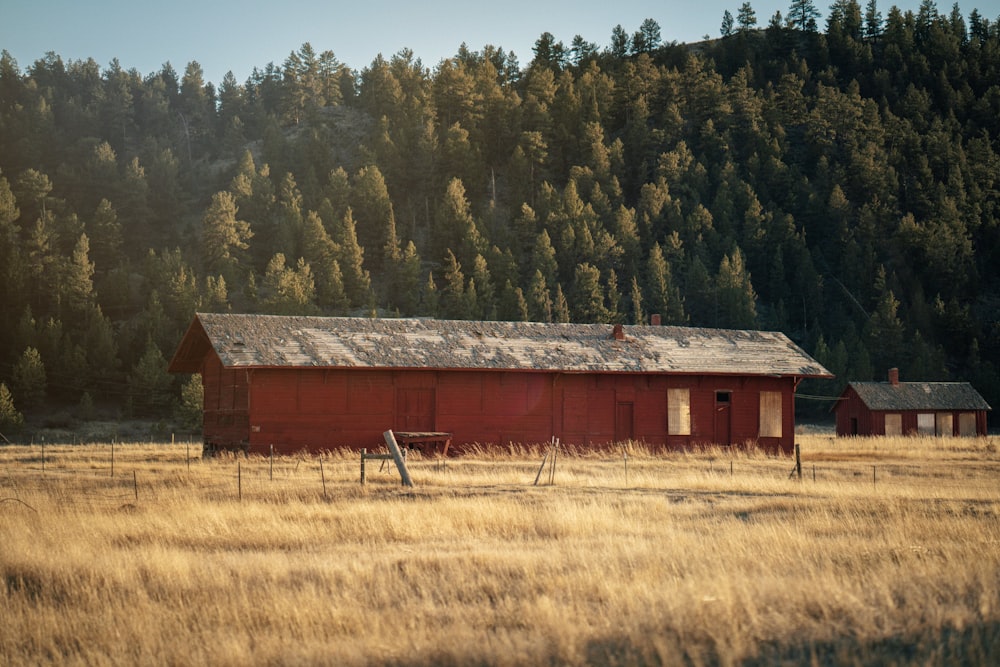 a red barn in a field with trees in the background